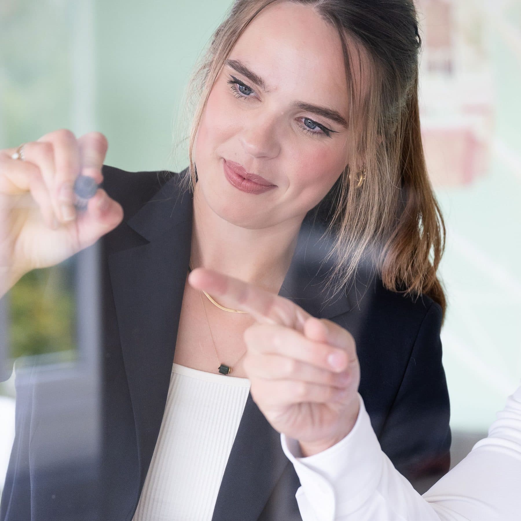 Beraterin von transformis zeigt auf eine Glaswand