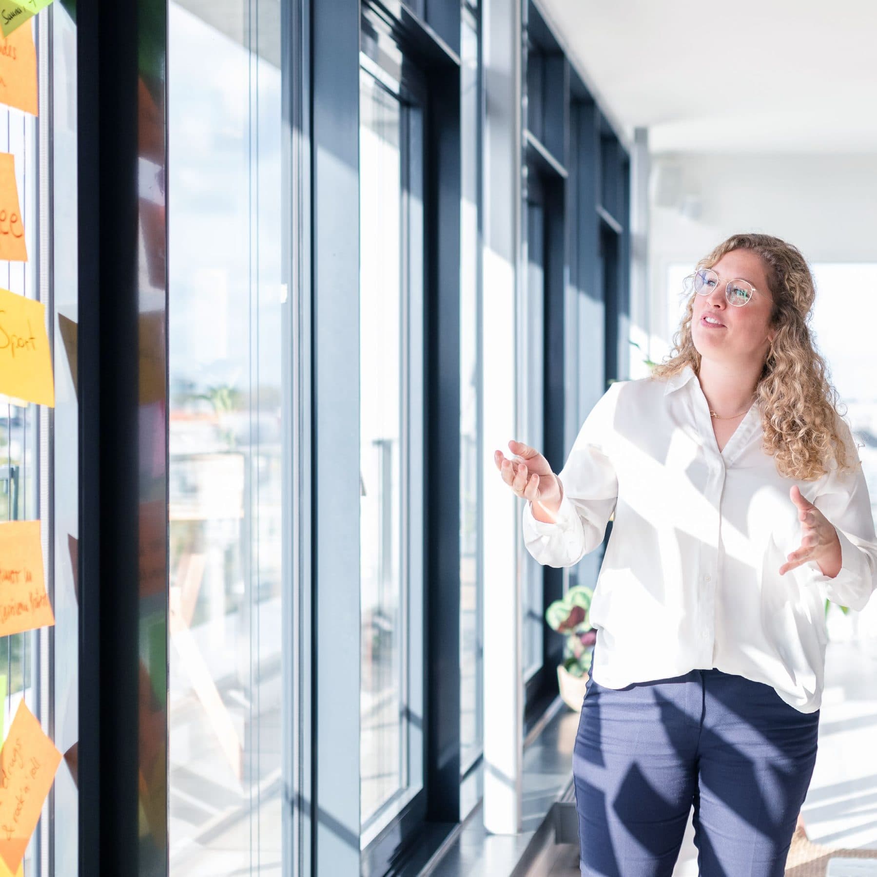 Beraterin von transformis am Fenster vor einer Wand mit Haftnotizen