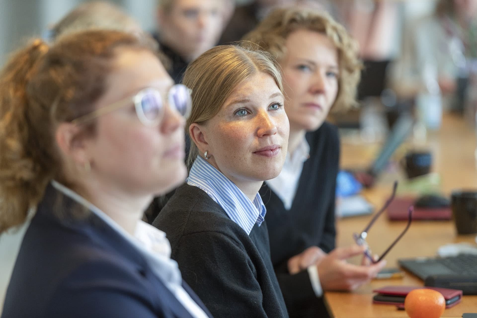 Teilnehmerinnen hören in einer Arbeitsrunde zu