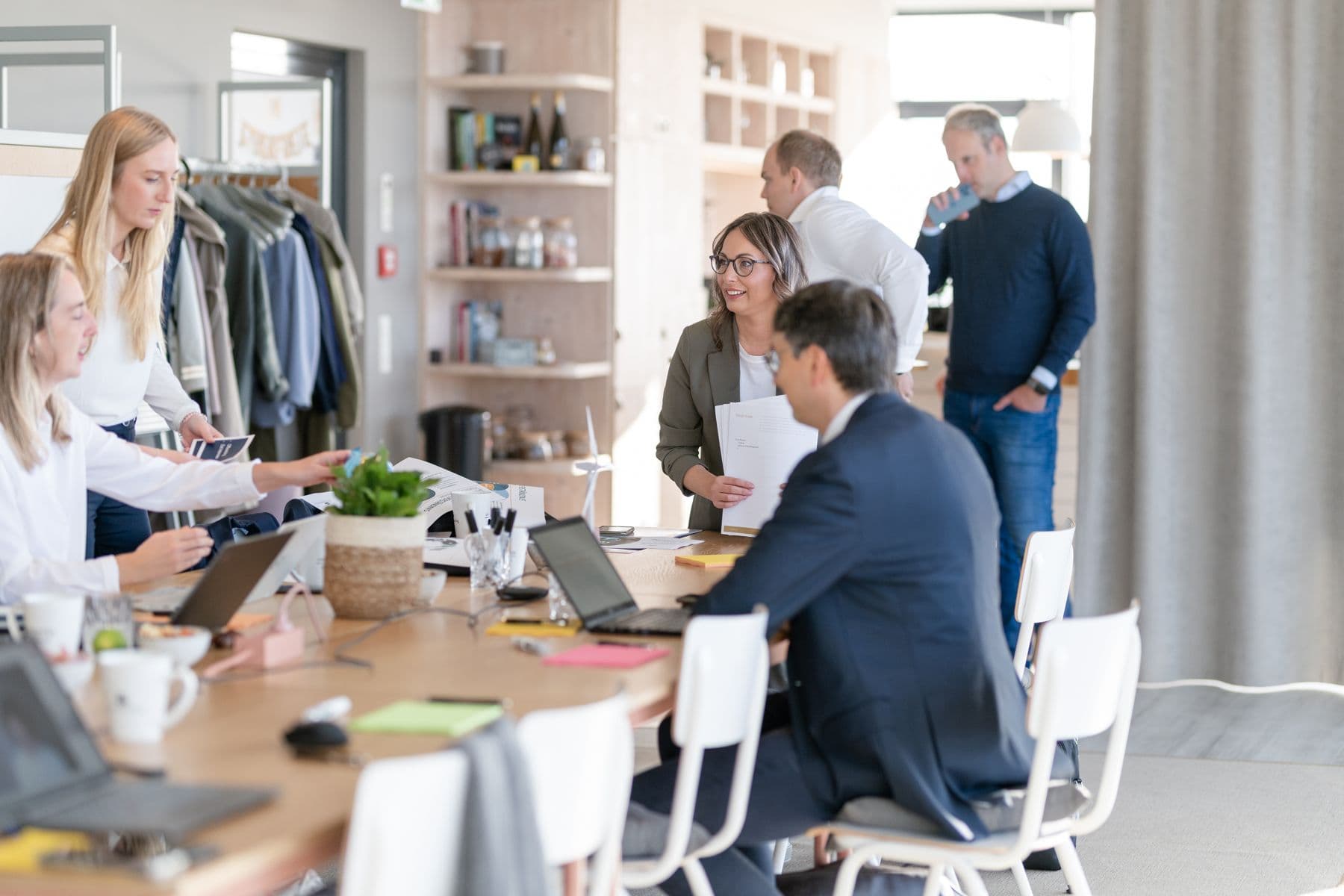 Arbeitsalltag im Büro von transformis, mehrere Gespräche an langen Tischen