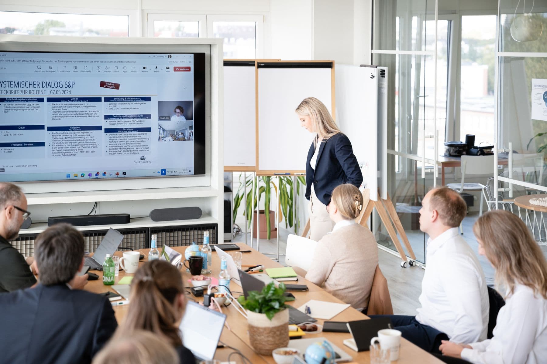 Präsentation auf einem großen Bildschirm vor einer Arbeitsgruppe